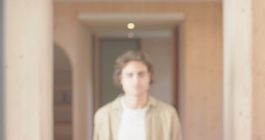 Man standing hall in tech demo, focusing initiating pink light gliding across face, revealing smile. Ambient, cinematic, futuristic, introspective, innovative, minimalistic, mood