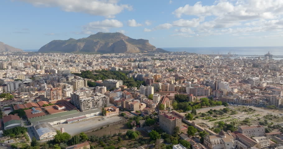 Aerial view of the city of Palermo, Sicily, Italy. In the background is the Monti Pellegrino Tower, which dominates the city and overlooks the Mediterranean Sea. In foreground there is Zisa palace.
