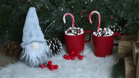 Holiday cheerful gnome with grey hat atop white sleigh, joined by two red mugs with hot chocolate, surrounded by pinecones, glowing golden bells, lush green branches, bringing festive energy  - Powered by Shutterstock - Get 15% off with code: PIKWIZARD15