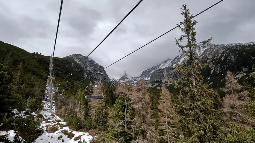 An open ski lift. The moving seat of a ski lift against the backdrop of mountain slopes. Tatra Mountains, Slovakia.