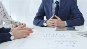 Business team engaging in a corporate meeting, discussing strategies while analyzing financial charts and graphs on a digital tablet alongside printed documents - Powered by Shutterstock - Get 15% off with code: PIKWIZARD15