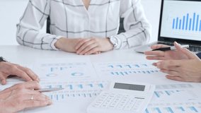 Business people professionals in a meeting analyze financial reports, charts and graphs on laptop and paper, using calculator to discuss strategy, budgeting and teamwork decisions - Powered by Shutterstock - Get 15% off with code: PIKWIZARD15