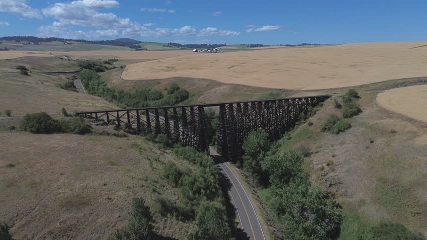 Abandoned railroad trestle in Idaho. Flight passes over the trestle and shows the trestle, canyon below, and surrounding plains of the area.