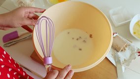 Hands whisking batter in yellow bowl - home baking with milk, eggs and flour; close-up cake or pancake mix. - Powered by Shutterstock - Get 15% off with code: PIKWIZARD15