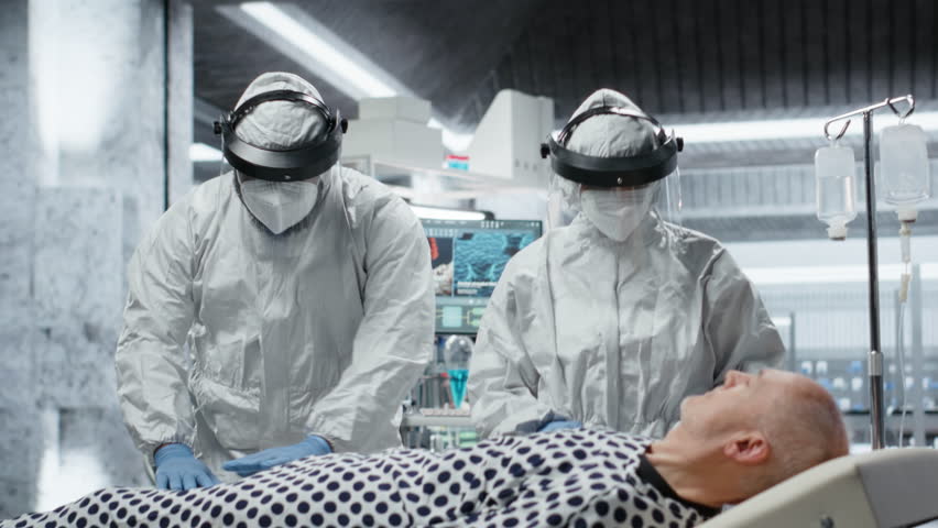 Doctors team in hazmat suits examining patient with infection symptoms in a secure laboratory, medical testing and diagnostics to prevent disease spread and support global healthcare. Camera B. - Powered by Shutterstock - Get 15% off with code: PIKWIZARD15