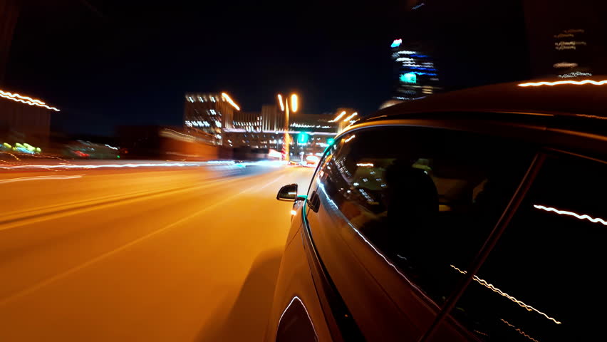 Motion timelapse of a night car driving in the city . view from the car side window 