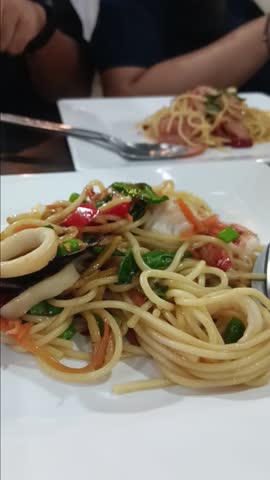 Spaghetti with clams, squid, and shrimp.Place in a ceramic plate.