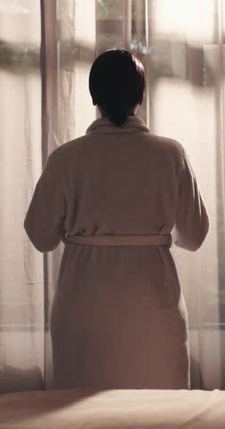 Morning, open curtains and woman at resort with window, gratitude and reflection on holiday trip. Back, relax and female person in bedroom with new day, travel and calm on start of vacation.