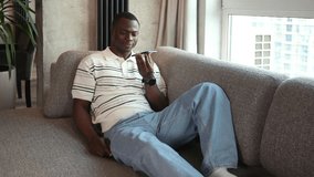 Confident young african man holding smartphone near mouth for recording voice message or activating digital assistant. - Powered by Shutterstock - Get 15% off with code: PIKWIZARD15