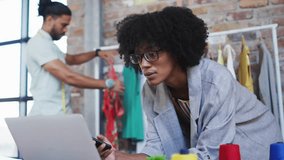 Fashion designer comparing device data upon making call with data icons floating. Creative, analytics, collaboration, industrial, apparel, technology, professional - Powered by Shutterstock - Get 15% off with code: PIKWIZARD15