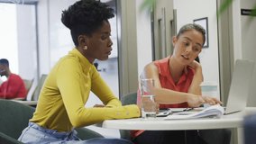 Two marketers opening binder at table, interpreting social media metrics via floating icons. Collaboration, teamwork, analytics, productivity, modernoffice, professional, dataanalysis - Powered by Shutterstock - Get 15% off with code: PIKWIZARD15