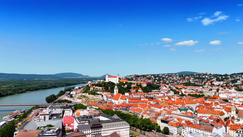 Beautiful sunny cityscape of the old town of Bratislava, Slovakia. Approaching the famous Bratislava Castle over the Danube.