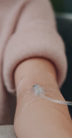 Arm, IV drip and needle in clinic for wellness, health and vitamin c fluid in vein for detox. Healthcare, medicine and patient person with closeup for immunity, nutrients or intravenous therapy