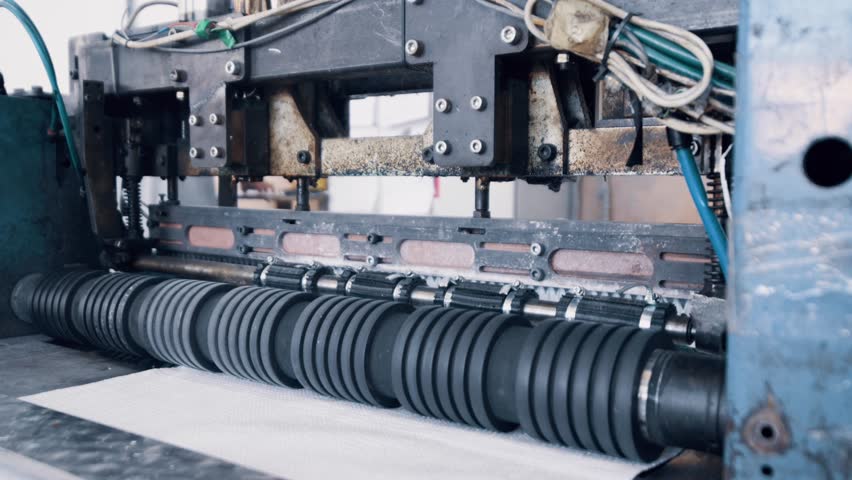 Polypropylene bags production. The guillotine machine cuts pieces of material for bags.