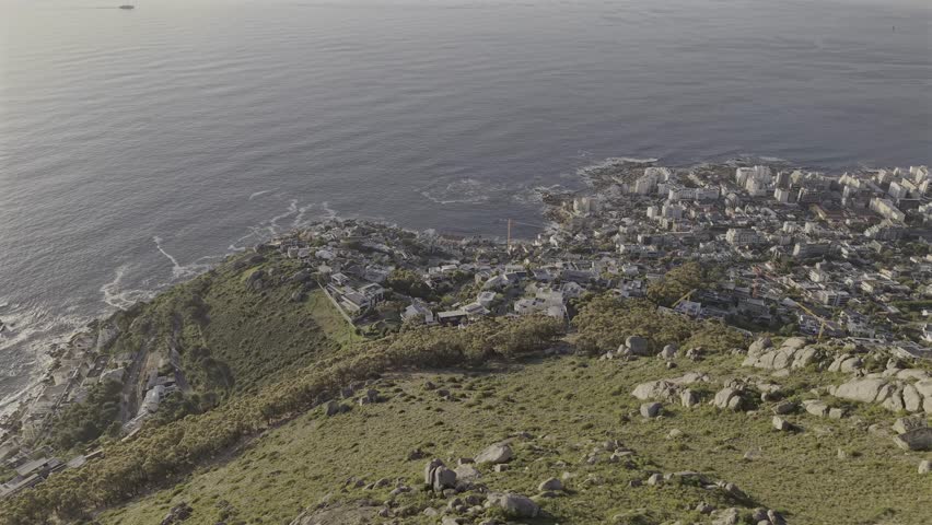 Cape Town drone video from Lions Head slowly facing down toward Sea Point and the coastline filled with homes and traffic below