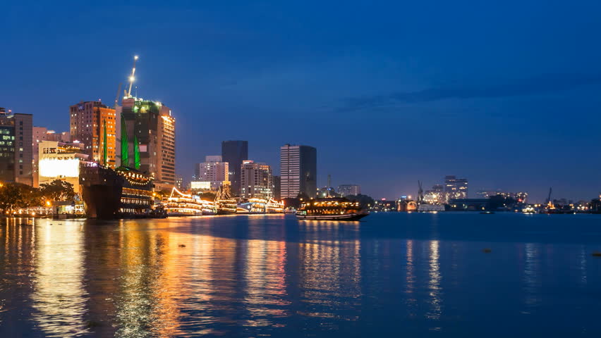 Timelapse Skyline of Ho Chi Minh City at night with Vietnamese junks on the