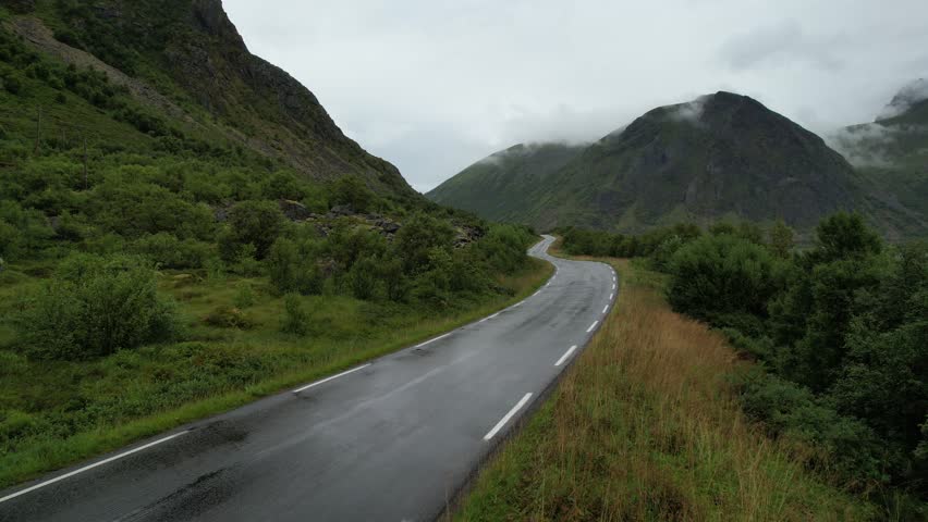Drone 4k aerial footage of rural road passing through mountains in lofoten islands nordland, Norway