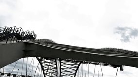 Low angle view of steel truss bridge with intersecting beams silhouetted against dramatic cloudy sky. Urban infrastructure, industrial architecture and geometric engineering design concept. - Powered by Shutterstock - Get 15% off with code: PIKWIZARD15