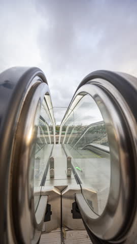 Timelapse of blurred rush of people on escalators entering and exiting metro station in barcelona vertical