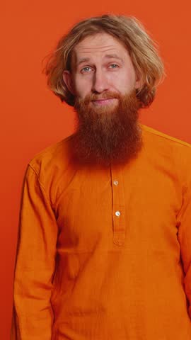 Caucasian man showing loser gesture and pointing on you, blaming accusing for unsuccess, expressing disrespect, mocking your failure, bullying abuse. Young guy isolated on orange background indoors