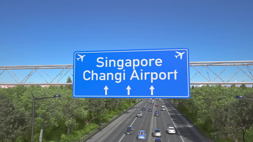 Blue motorway sign for Singapore Changi Airport with an airliner flying above along the road toward the airport