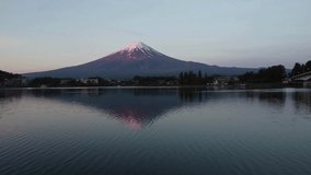Spectacular sunrise view of Mount Fuji with soft pink hues illuminating snow-capped peak. Tranquil lake mirrors stunning scenery. Peaceful atmosphere in serene Japanese landscape. - Powered by Shutterstock - Get 15% off with code: PIKWIZARD15