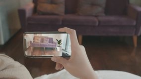 A hand holds a smartphone, showcasing a stylish interior featuring a couch and a potted plant. This image highlights modern home decor and the use of technology in documenting living spaces. - Powered by Shutterstock - Get 15% off with code: PIKWIZARD15