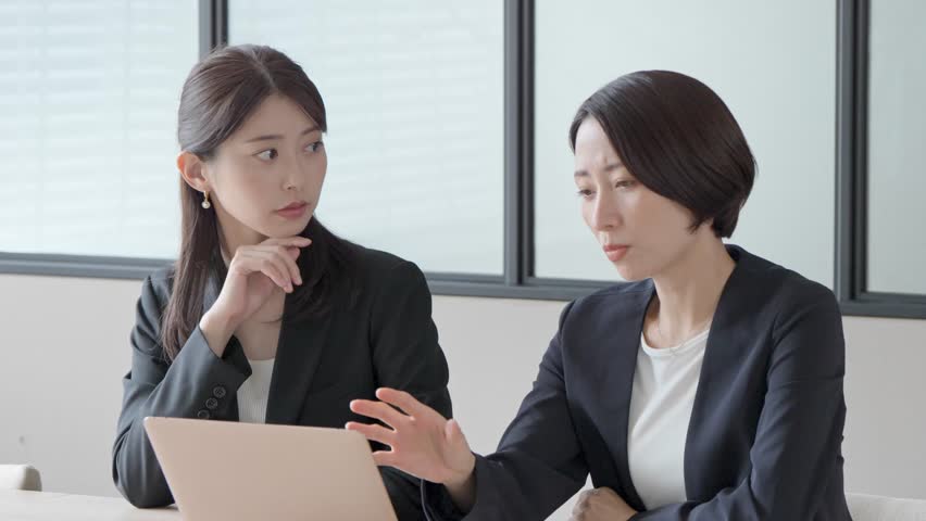 Women in suits talking in the office