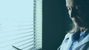 Senior female doctor gazing at blinds, data charts emerging, studying tablet for medical analysis. Health, technology, analytics, innovation, professionalism, digital, medical - Powered by Shutterstock - Get 15% off with code: PIKWIZARD15