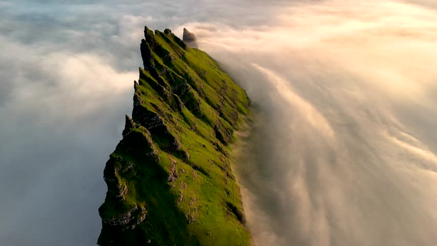 Discover the stunning cliffs of Drangarnir in the Faroe Islands, surrounded by enchanting fog and lush greenery. This majestic landscape captures the essence of natures beauty at sunrise.