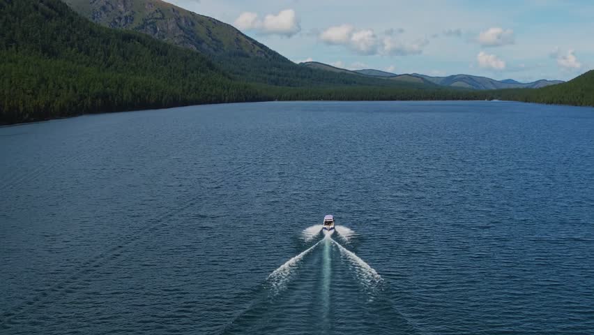 Aerial view Speed boat move on beautiful Multinskoye lake in mountains Altai.