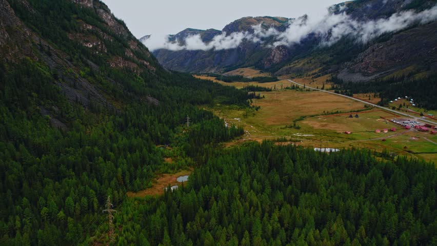 Aerial beautiful landscape Altai, blue geyser lake with clear water surrounded by forest Aktash mountains, Altay Russia drone view.