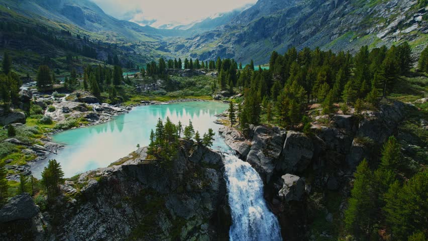 Aerial view beautiful nature reserve landscape turquoise Kuyguk waterfall and Kuiguk lake with clear blue water from glaciers in Altai mountains Russia..