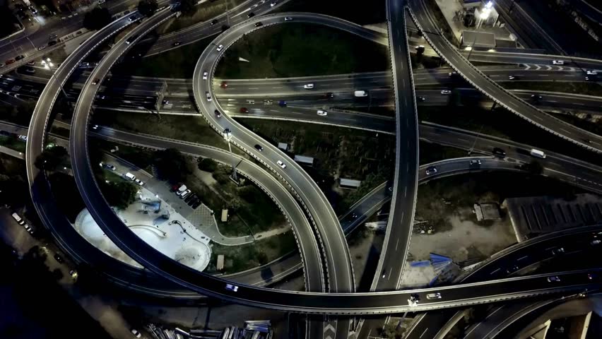 Overhead view captures vibrant urban highway interchange at night with flowing traffic, illuminated roads, and intricate design elements highlighting modern transportation infrastructure. - Powered by Shutterstock - Get 15% off with code: PIKWIZARD15