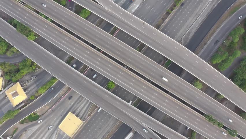 Captivating overhead perspective revealing intricate network of highways and overpasses with vehicles navigating busy urban infrastructure during daytime.