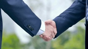 A professional video showing two businessmen shaking hands, symbolizing partnership, trust, and successful business agreement in a corporate environment with a confident and positive tone. - Powered by Shutterstock - Get 15% off with code: PIKWIZARD15