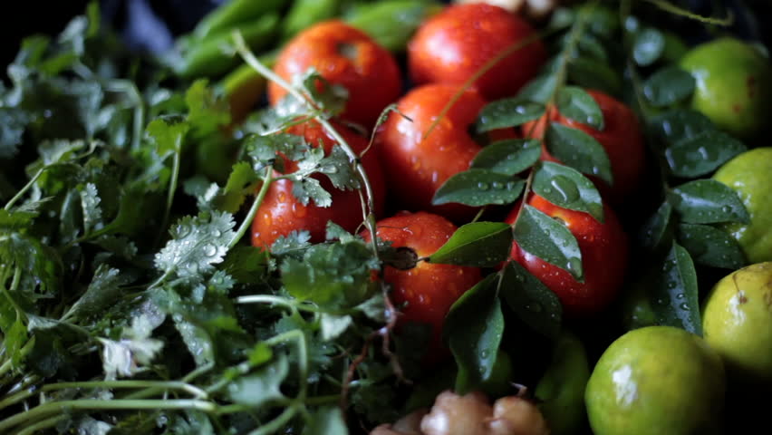 Fresh Ingredients with Water Droplets – Tomatoes (Solanum lycopersicum), Green Chillies (Capsicum annuum), Lemon (Citrus limon), Coriander (Coriandrum sativum), Curry Leaves (Murraya koenigii)  - Powered by Shutterstock - Get 15% off with code: PIKWIZARD15