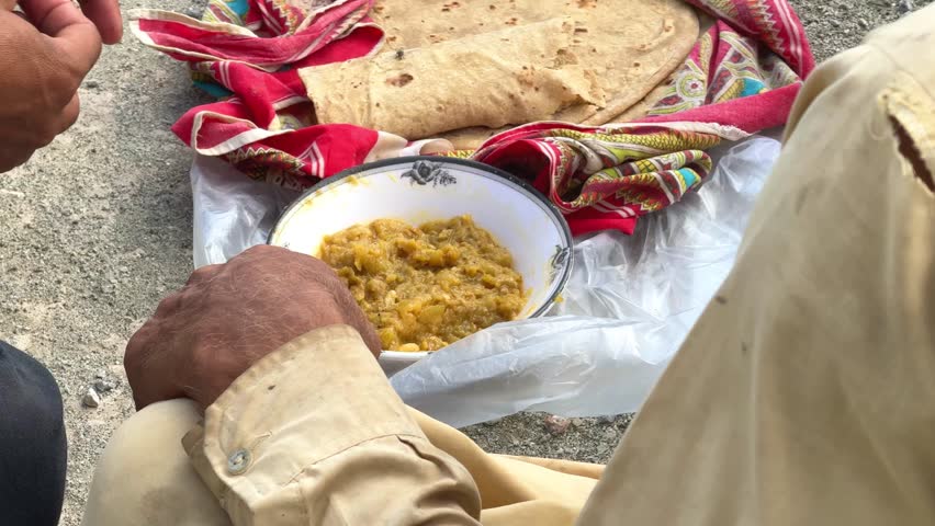 Poor labor eating lunch at work break, Poor worker eats food during lunch break, Labor eat simple meal at work break.