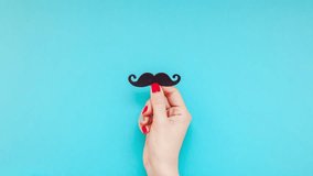 Creative flatlay top view retro black paper photo booth props moustaches woman hands turquoise background copy space. Men health awareness month fathers day masculinity concept blog social media - Powered by Shutterstock - Get 15% off with code: PIKWIZARD15