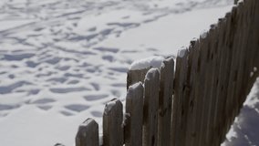 Rustic wooden fence covered with white snow in early morning in village or town. Cold winter season outdoors as snowfall of thick snow seen in backyard of house or family home in suburb area or garden - Powered by Shutterstock - Get 15% off with code: PIKWIZARD15