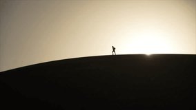 Silhouette of a lone hiker conquering desert dunes at sunrise, perfect for adventure travel marketing and inspirational messages of perseverance - Powered by Shutterstock - Get 15% off with code: PIKWIZARD15