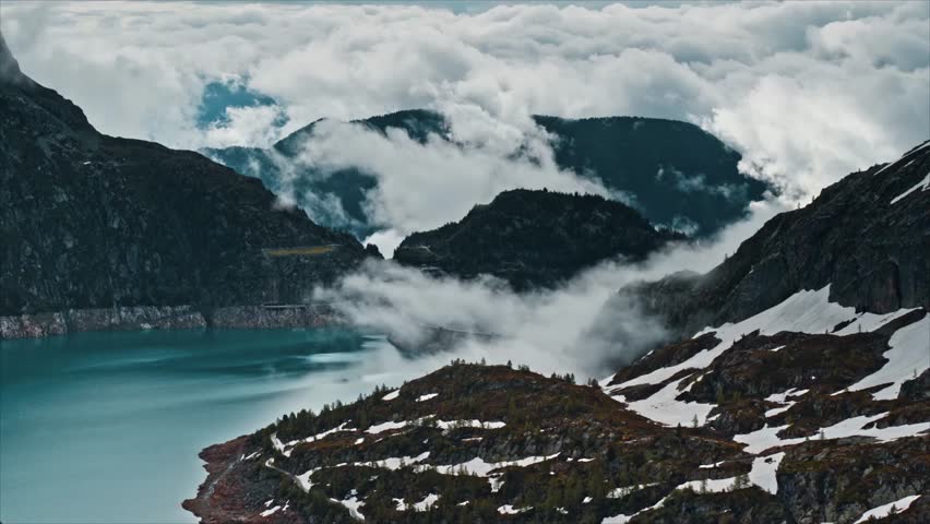 Majestic mountain landscape with turquoise lake and dramatic clouds creating a sense of awe and wonder, perfect for travel or nature-themed projects
