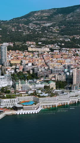 Spectacular 4K vertical aerial video of Monaco showcasing luxury waterfront hotels, casino district, and hillside cityscape. Stunning drone footage capturing Mediterranean coastline, ideal for mobile.