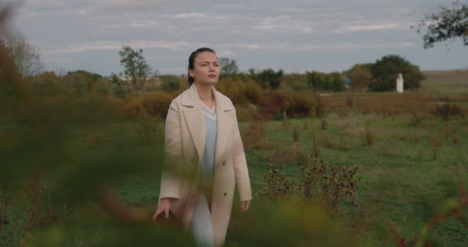 Woman photographer with big lens takes a picture at the autumn day