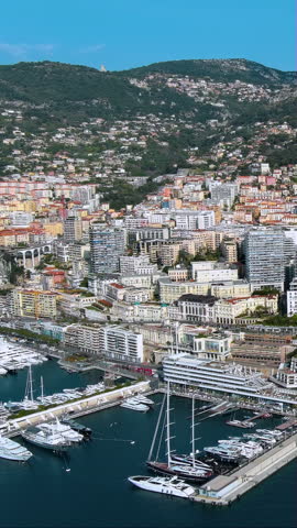 Stunning 4K vertical aerial video of Monaco's luxury harbor with mega yachts, dense hillside architecture and Mediterranean coastline. Epic drone footage with exclusive waterfront, perfect for mobile.