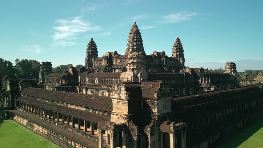 Drone captures stunning side movement orbiting around Angkor Wat Temple in Cambodia, showcasing its iconic towers and architecture. High quality cinematic stock video for travel promos, documentaries