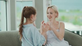 Caucasian mother and little daughter smiling while playing clapping hands game at home, enjoying fun family bonding and happy parenting moments together. - Powered by Shutterstock - Get 15% off with code: PIKWIZARD15