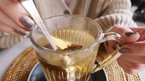 Female Hands stirring steaming cup of hot tea with lemon and cinnamon, anise in cozy interior, warmth and relaxation during a cold autumn morning
 - Powered by Shutterstock - Get 15% off with code: PIKWIZARD15