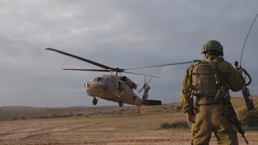 Cinematic slow motion ground view of a military Black Hawk helicopter and special forces soldiers showing teamwork during a medical evacuation operation at sunset