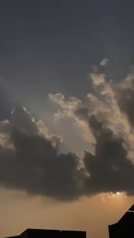 There is a dark silhouette of a rooftop or building at the very bottom of the frame